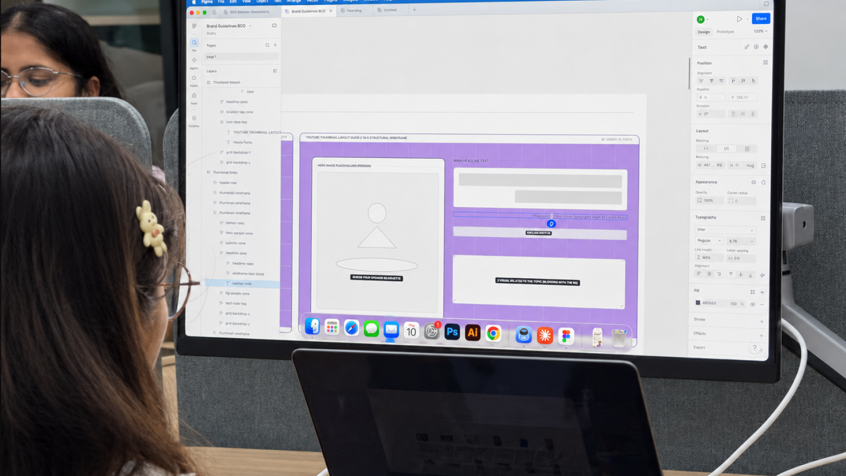 A MoreTasks designer working on a layout in Figma at a large monitor